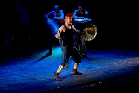 Angus Little smashing bin lids in a performance of 'Stomp'.